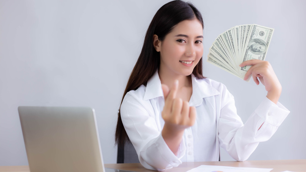 Woman holding hundred dollar bills