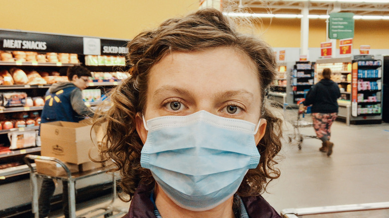 Masked Walmart customer in front of unmasked Walmart employee