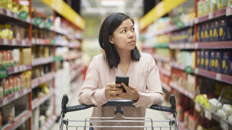 Woman holding phone in market