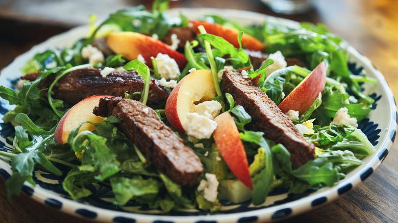 salad with steak on it 