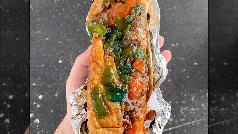 Person holding a sweet steak sandwich