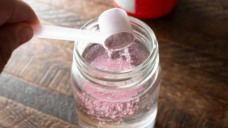 Scooping electrolyte powder into glass of water