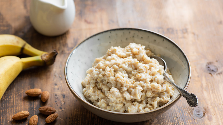 Bowl of oatmeal with bananas, almonds, and milk