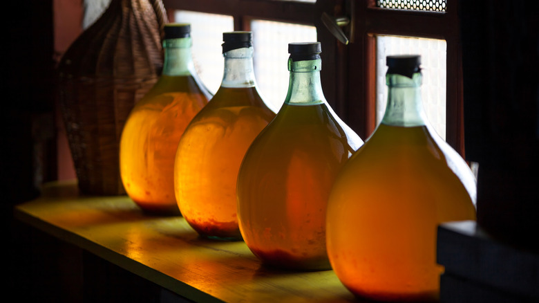 four carboys filled with homemade wine 