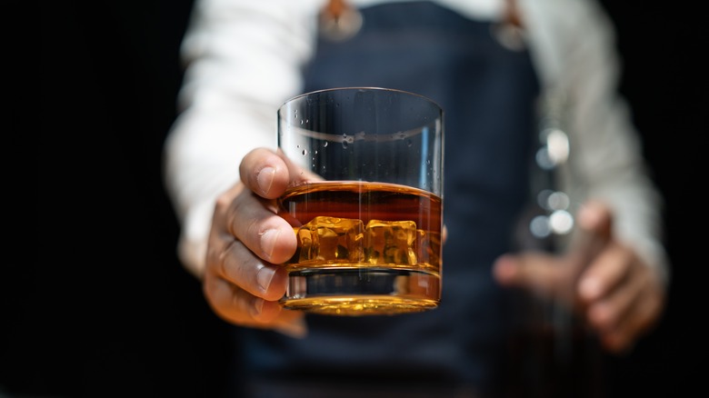 bartender serving whiskey in glass