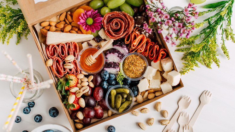 A cheese board with meats on a wood surface