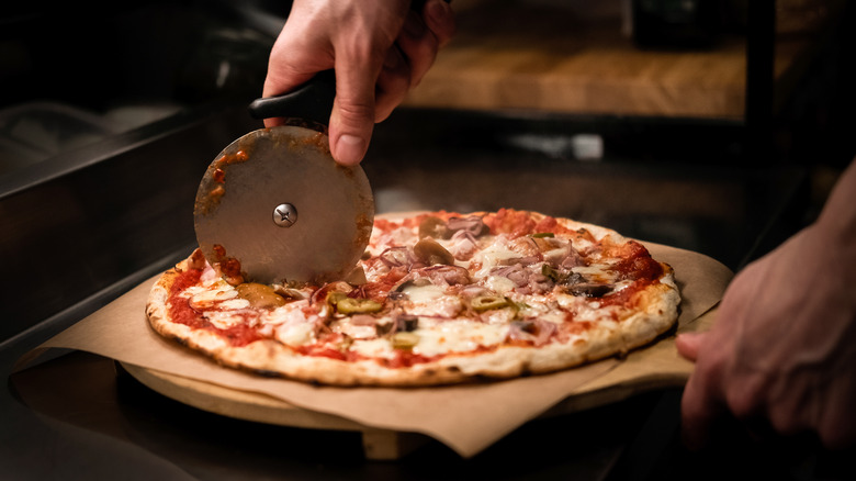 cutting pizza on parchment