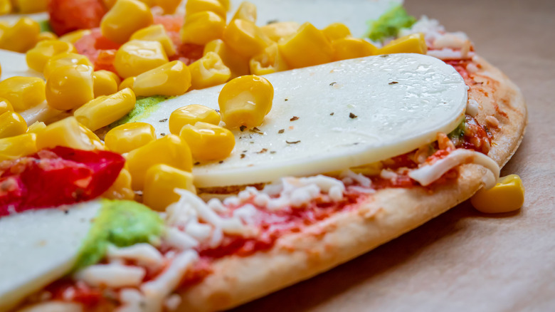 close up of mozzarella and corn on frozen pizza