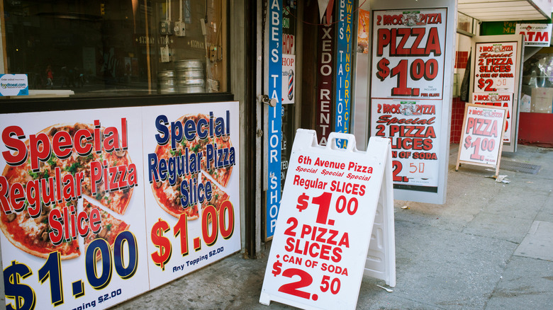 signs advertising one dollar pizza