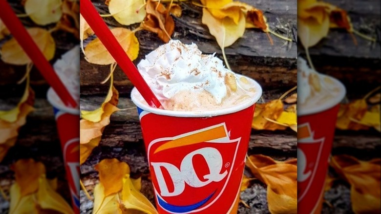 A pumpkin spice Blizzard against a backdrop of fall leaves 