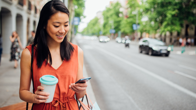 Woman walking with coffee cup in hand 