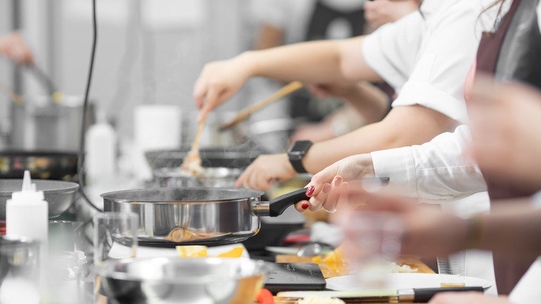 A line of cooks working in a kitchen