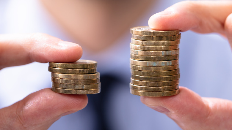 Person holding different sized coin stacks