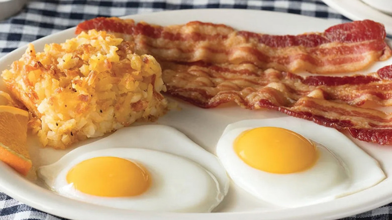 Plate of Cracker Barrel hash browns, bacon, and eggs