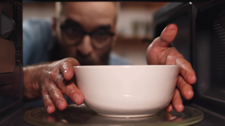 Bowl being taken out of microwave