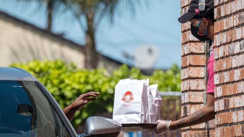 Wendy's employee passing drive-thru bags