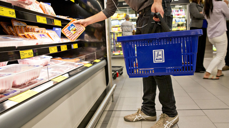 Shopper picking out Aldi sausages