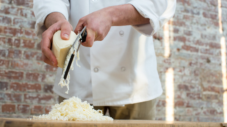 Chef grating cheese restaurant setting