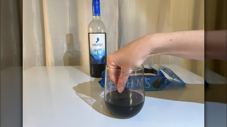 hand dipping oreo into wine