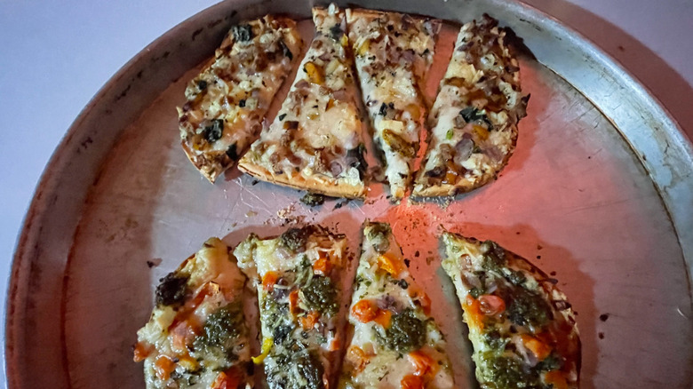 two Daiya flatbreads cut into pieces on a pizza serving tray