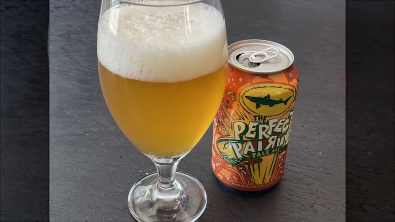 a beer in a glass with a can