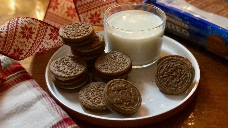 A plate of limited edition gingerbread oreo cookies with a glass of milk