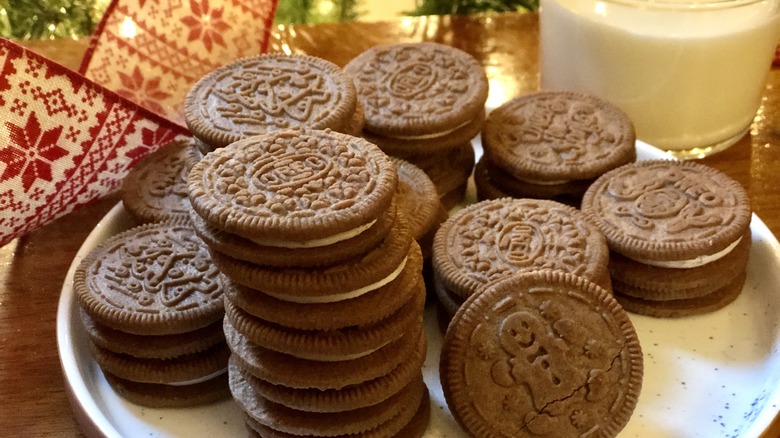 a plate with limited edition seasonal holiday gingerbread oreo cookies on a plate with a glass of milk