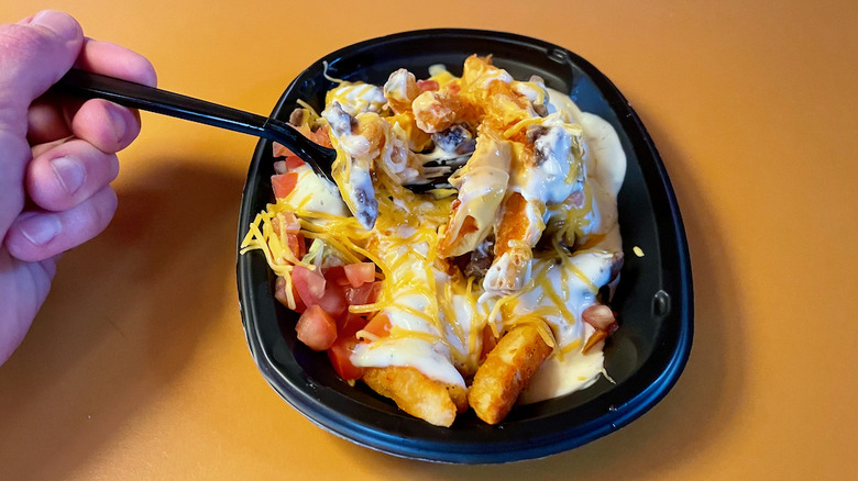 nacho fries with hand holding fork