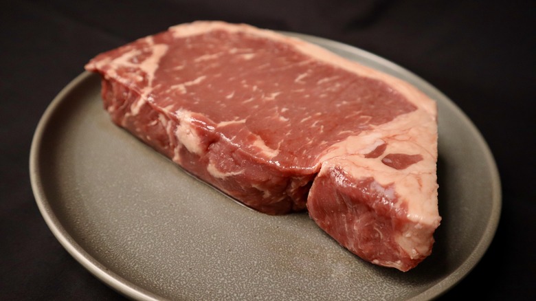 raw New York strip steak on plate