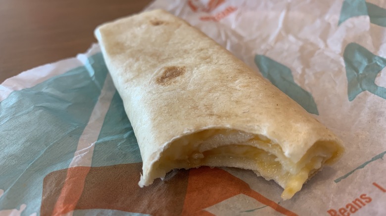 Taco Bell cheesy roll-up  with bite taken