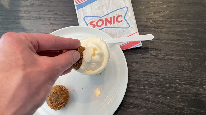 dipping a cookie dough bite into ice cream