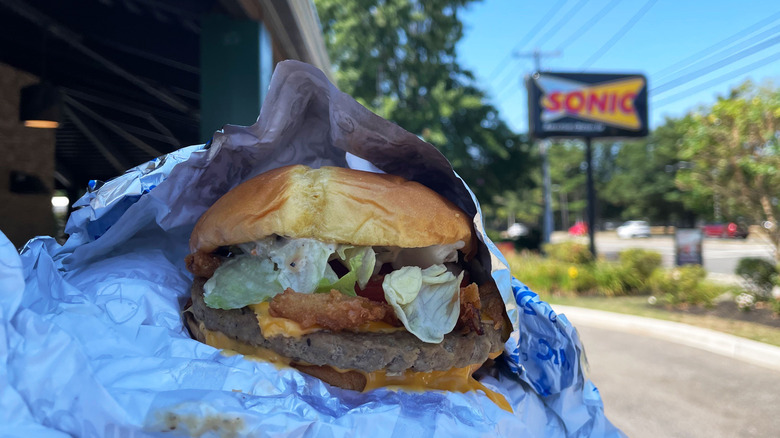 a burger unwrapped before a Sonic