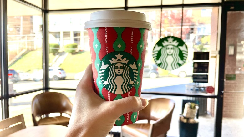 Hand holding Starbucks red cup