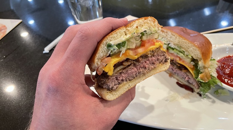 a hand holding a burger