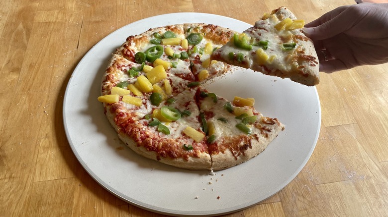 Pineapple pizza with a slice lifted