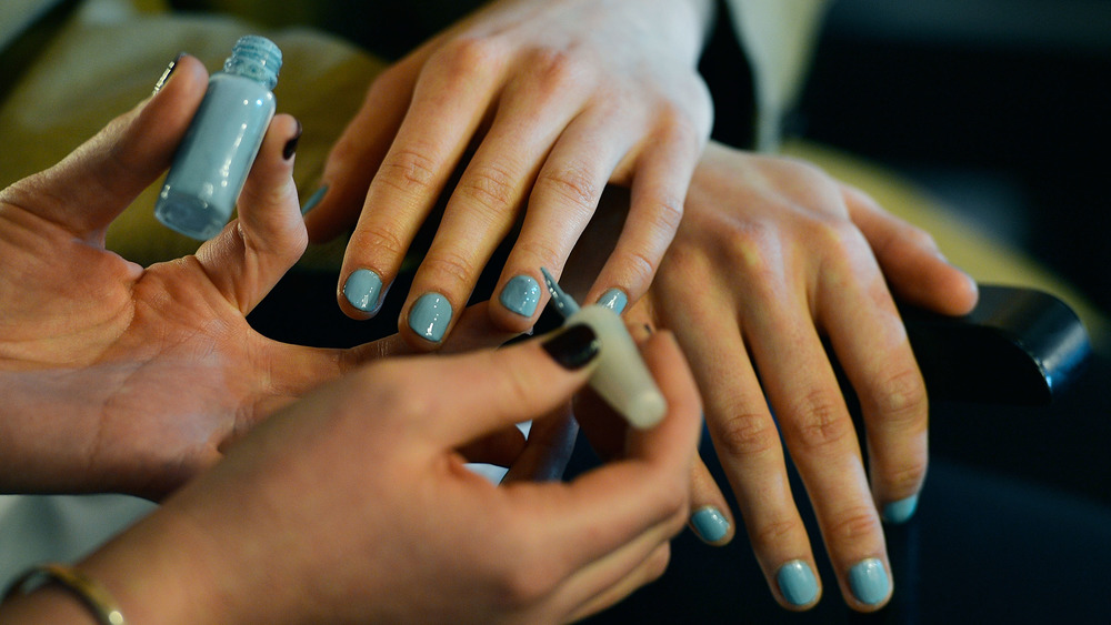 person painting fingernails 