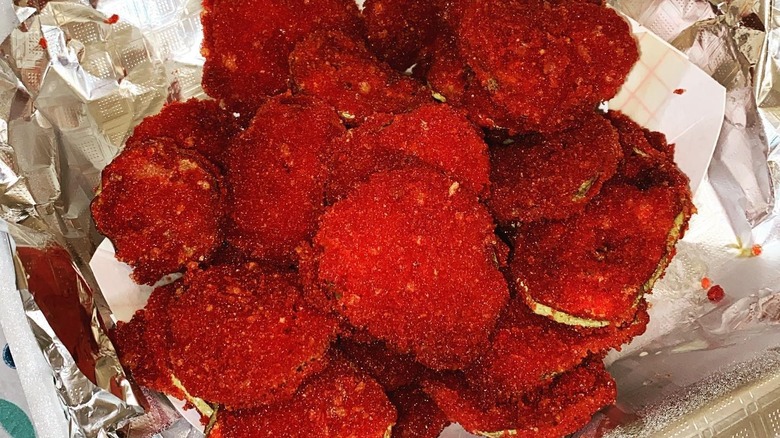 Pickle slices covered in Hot Cheetos crumbs