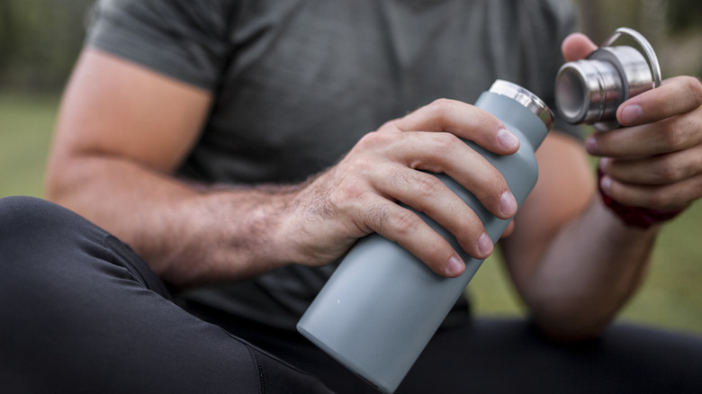 person opening water bottle 