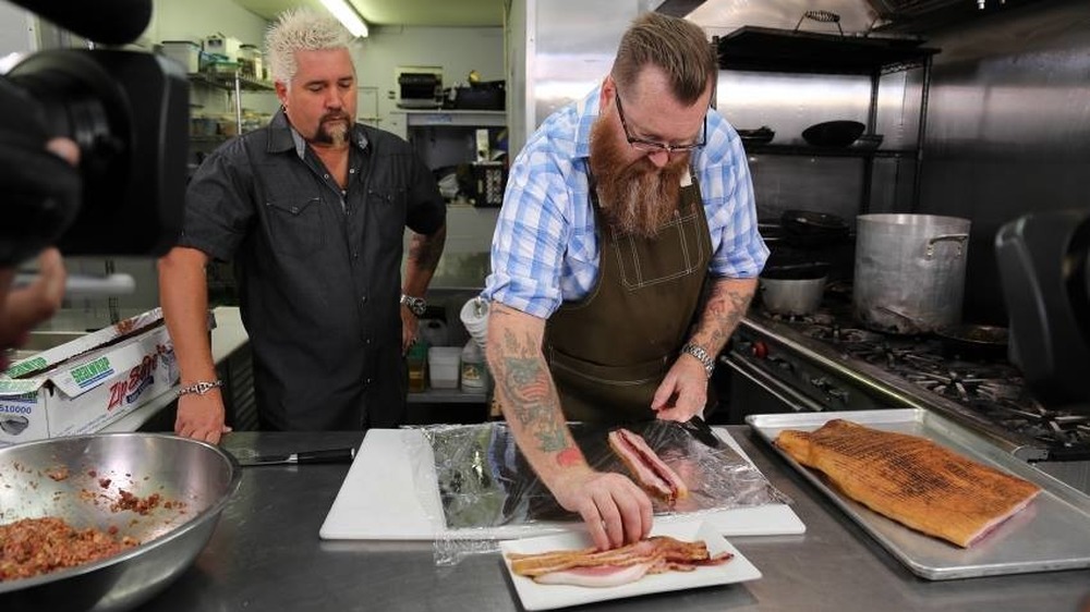 Guy Fieri watches chef prep food in kitchen