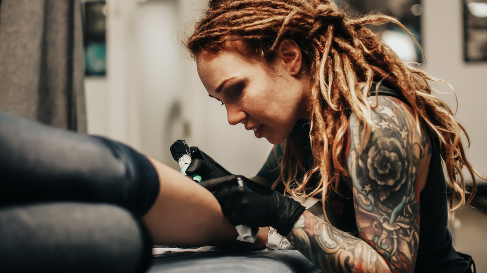 woman tattoo artist with dreadlocks