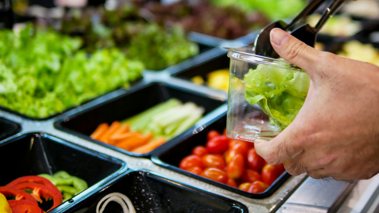 Person serving self at salad bar