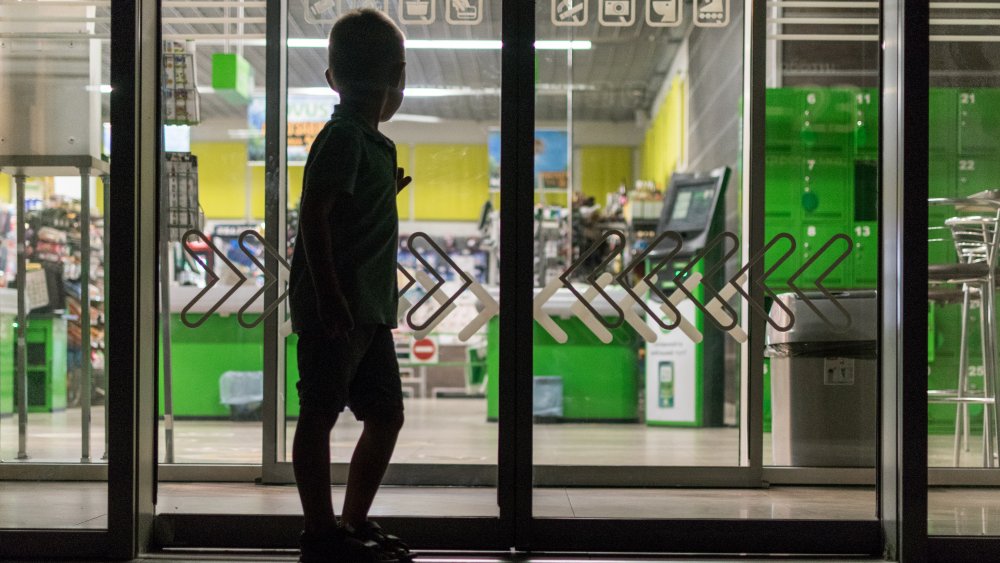 store closed at night with boy outside entrance