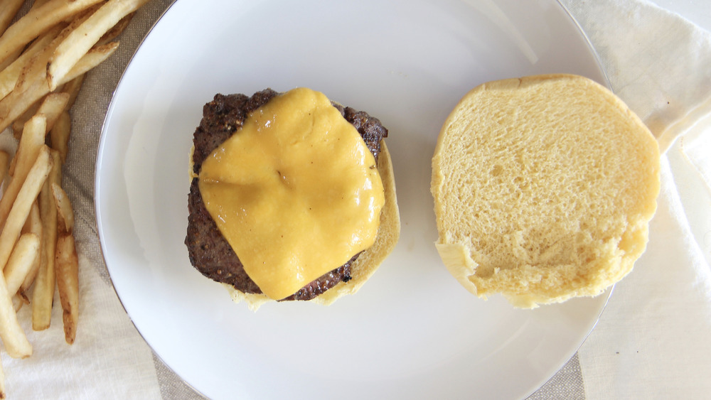 a cooked burger patty with cheese melting on top