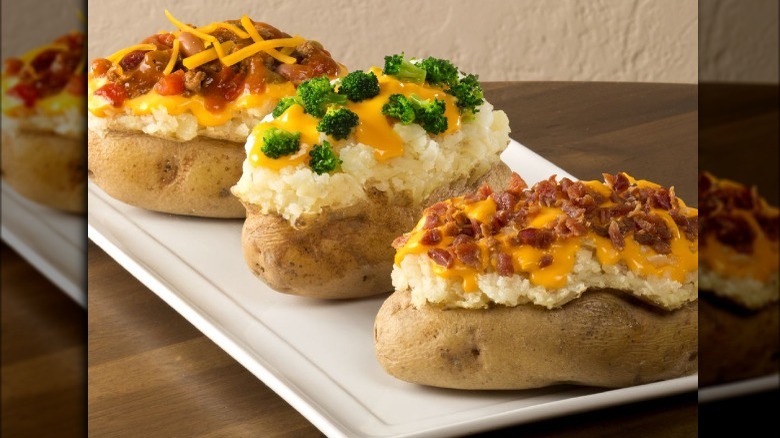 A plate with three different Wendy's baked potatoes