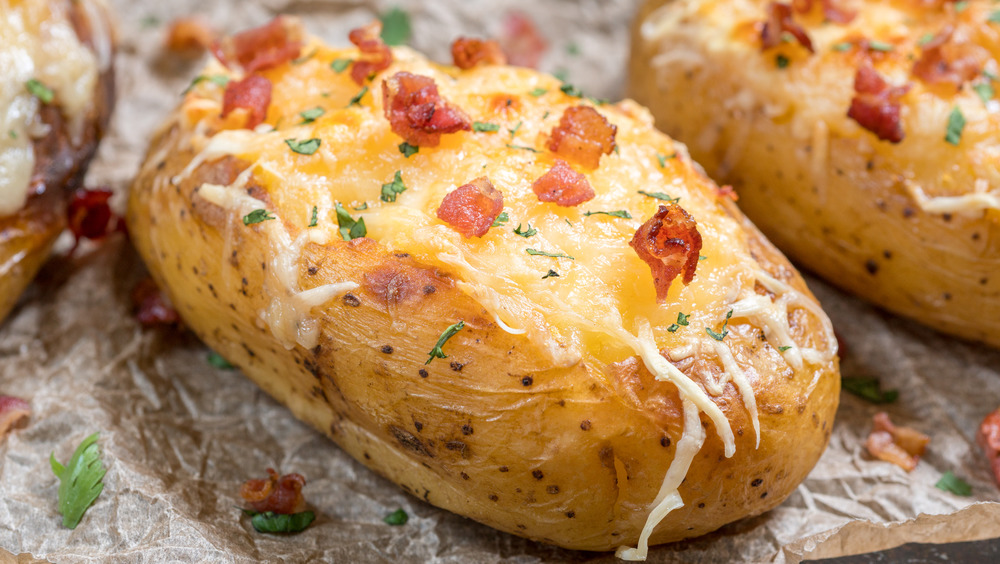 Loaded baked potatoes covered with cheese, chives, and bacon