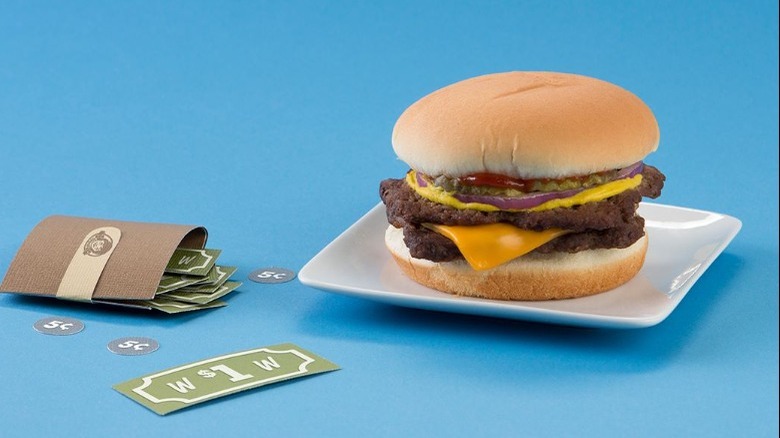 A Wendy's Double Stack on a plate next to fake money.