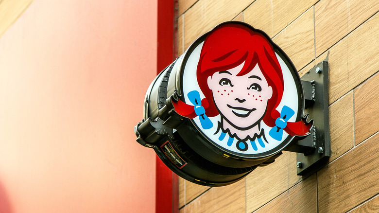 A Wendy's logo sign mounted on the wall