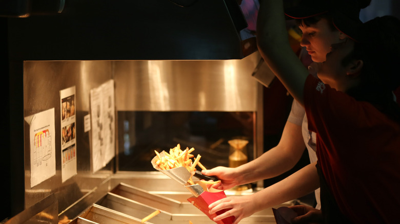 Person filling a container with Wendy's fries