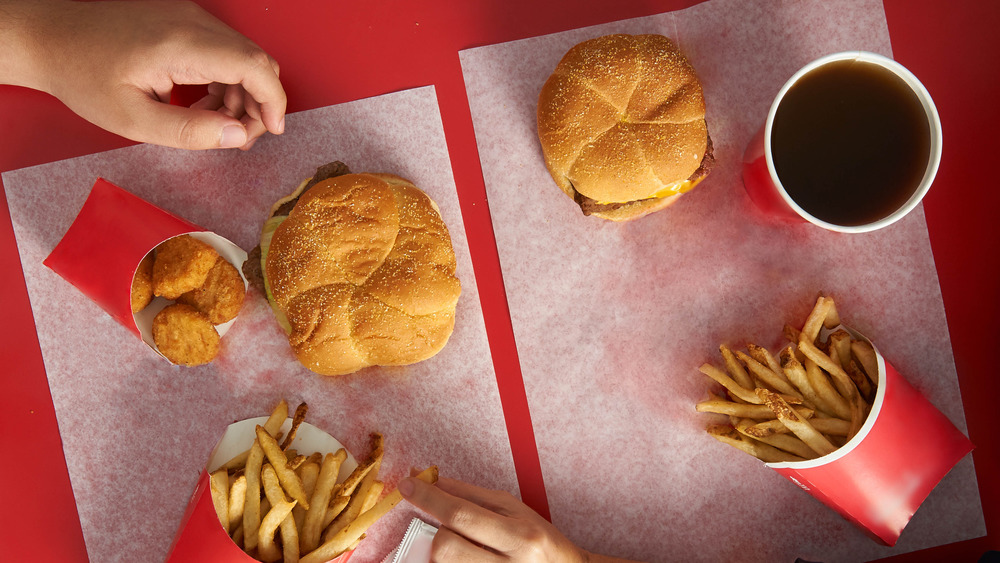 people eating Wendy's food on a red background