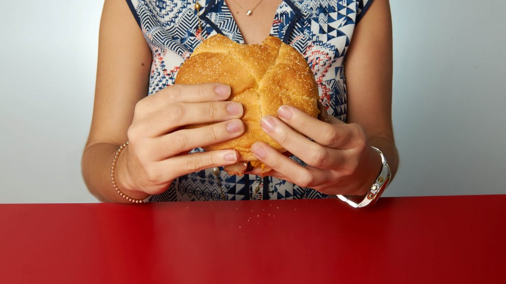 A woman holding a Wendy's burger